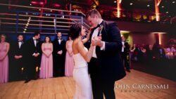 Newlyweds dancing with bridal party behind