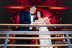 Newlyweds toasting from balcony railing