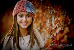 Teenage girl smiling outdoors in a knit hat