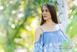 Yearbook photo of a girl in a blue top standing outdoors