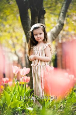 Little girl standing near tulips outdoors
