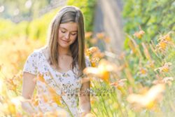 Teenage girl standing outdoors near flowers