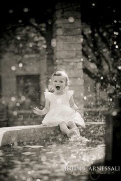 Black and white portrait of a little girl sitting outdoors