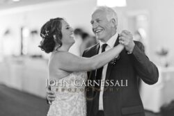 Black-and-white portrait of the bride and groom holding each other.