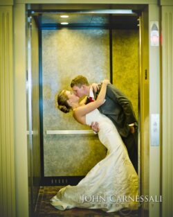 Bride and groom kissing outdoors in warm evening light.