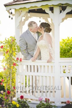 Bride standing on a porch in her wedding dress.