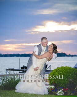 Newlyweds dipping at sunset waterfront