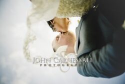 Close-up of the bride and groom kissing behind the veil.