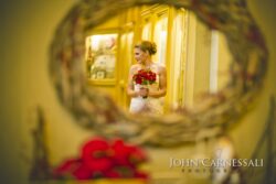 Bride standing in a grand hotel hallway.