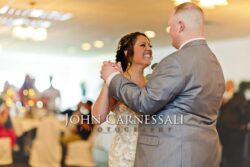 Bride and groom smiling while dancing at the reception.