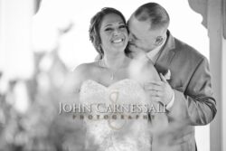 Bride laughing while groom kisses her cheek