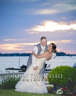 Bride and groom sharing a dip kiss near the waterfront.
