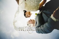 Low-angle portrait of newlyweds beneath veil