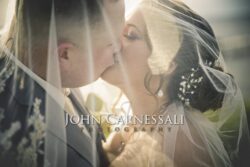 Close-up of couple kissing under soft veil