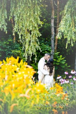 Bride and groom standing together in a flower garden