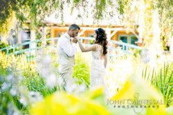 Bride and groom standing together in bright garden light