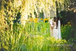 Bride and groom standing together in tall garden grass