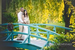 Bride and groom standing on a blue garden bridge