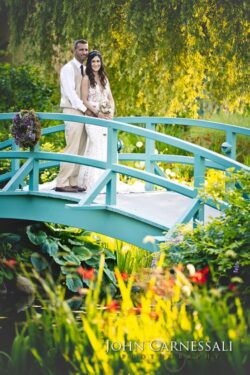 Bride and groom posing together on a blue bridge