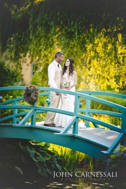 Couple posing on a blue bridge in the garden