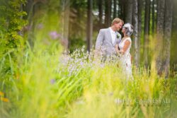 Bride and groom standing together in tall grass