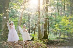 Magical looking family photo of two girls in woods with Fairy dust