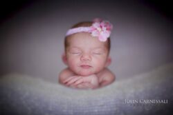Sleeping newborn with a pink floral headband