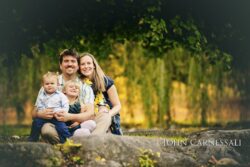 Family sitting together outdoors on a log