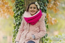 Smiling girl wearing a pink scarf outdoors