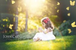 Little girl sitting in a sunlit field