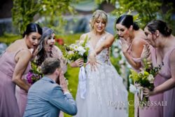 Bride showing off wedding ring as bridal party cheers