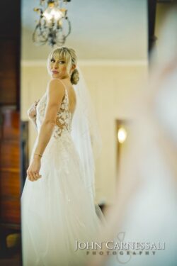 Bride looking in the mirror while getting ready