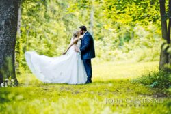 Romantic photo of bride and groom kissing in a wooded setting