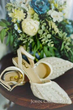 Bridal shoes, rings, stationery, and florals arranged for a flat lay