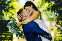 Bride and groom holding each other outside