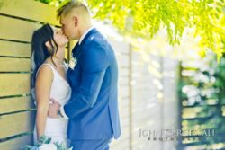 Bride and groom standing together in bright outdoor light
