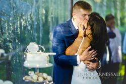 Bride and groom kissing beside the cake table