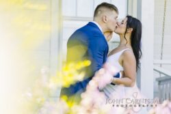 Bride and groom embracing with soft foreground blur